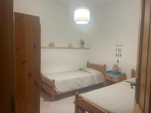 1 Schlafzimmer mit 2 Einzelbetten und einer Lampe in der Unterkunft Appartamento fronte spiaggia in Bari Sardo