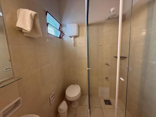 a bathroom with a toilet and a glass shower at Departamentos DE LA COSTA in Encarnación