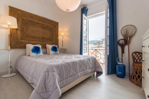 a bedroom with a large bed and a balcony at Beach And Mountain Apartment in Sesimbra