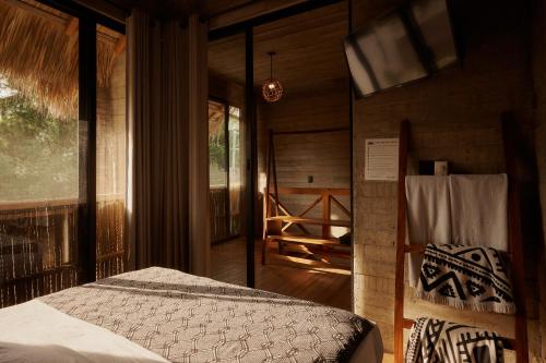 a bedroom with a bed in a room with a porch at Punta Tamarindo in Puerto Escondido