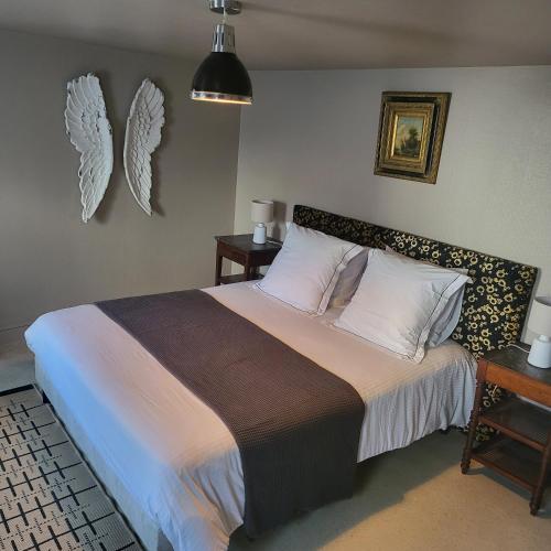 a bedroom with a large bed with white pillows at Le Figuier, Appartement centre d'Etretat avec balcon in Étretat