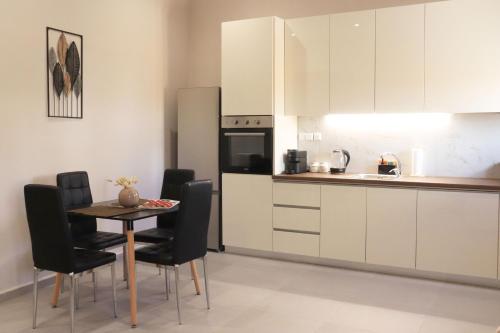 a kitchen with a table and chairs in a room at STV Royal Apartments 3 in Areopolis