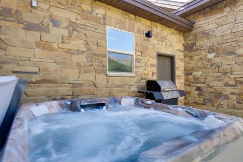 a hot tub in a room with a stone wall at 5 Mi to Main St Breck Mtn-View Duplex with Hot Tub in Blue River
