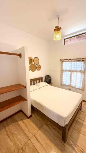 a bedroom with a large bed and a window at Terrazas Iguana in Máncora