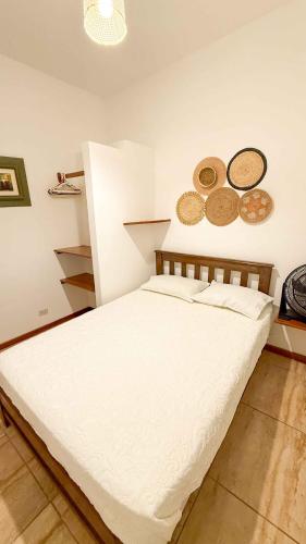 a bed in a room with plates on the wall at Terrazas Iguana in Máncora