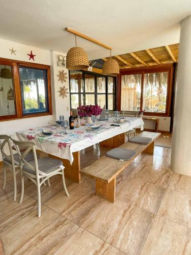 a dining room with a long table and chairs at Terrazas Iguana in Máncora