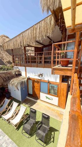 a group of chairs sitting on a balcony of a building at Terrazas Iguana in Máncora