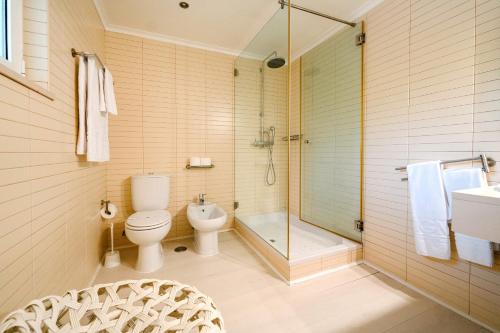 a bathroom with a toilet and a shower and a sink at Muthu Clube Praia da Oura in Albufeira
