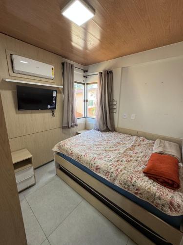 a bedroom with a bed and a television in it at Casa Lençóis Maranhenses in Barreirinhas
