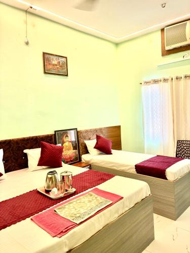 a hotel room with two beds and a table at Hotel Atharv in Varanasi