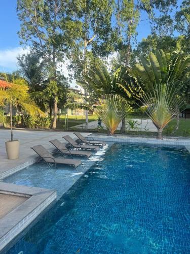 a swimming pool with chaise lounge chairs and trees at Casa Lençóis Maranhenses in Barreirinhas