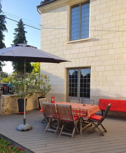 a table and chairs with an umbrella on a patio at Les Voies Blanches in Vouvray