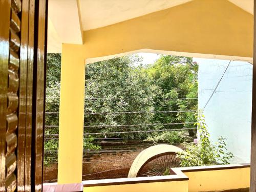 a window with a view of a brick wall at Hotel Atharv in Varanasi