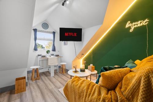 a living room with a couch and a green wall at The Cosy Place - BHX Airport, NEC, HS2 & RES World in Marston Green