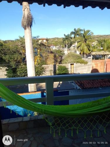 a hammock on a balcony with a palm tree at La Casa Agus Hospedagem in Búzios