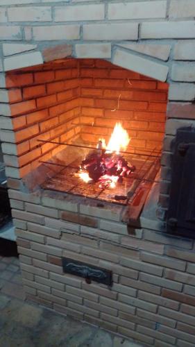 a brick oven with a fire in it at La Casa Agus Hospedagem in Búzios