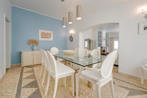 a dining room with a glass table and white chairs at Muthu Clube Praia da Oura in Albufeira