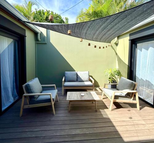 a patio with two chairs and a coffee table on a deck at Le Sounta in Saint-Pierre