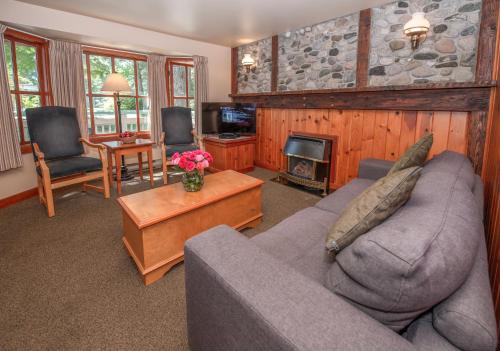a living room with a couch and a fireplace at Painter's Lodge in Campbell River