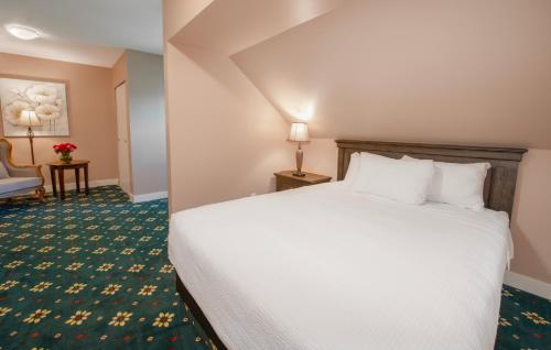 a hotel room with a bed and a chair at Painter's Lodge in Campbell River