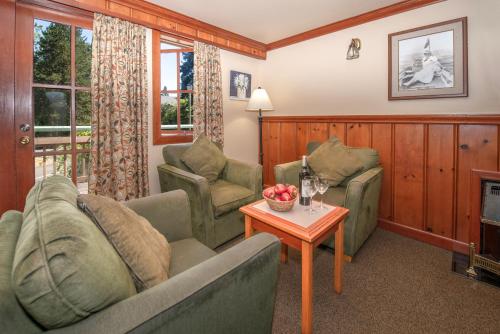 a living room with two couches and a table at Painter's Lodge in Campbell River