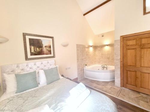 a bedroom with a bed and a bath tub at Courtyard Hot Tub in Garton