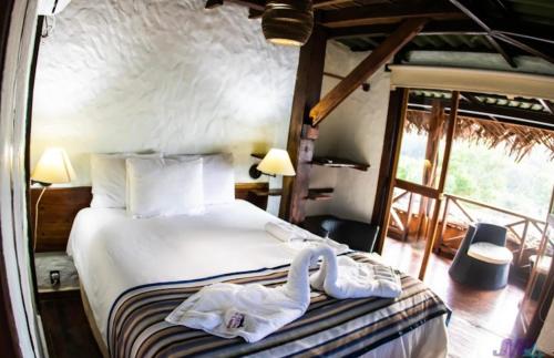 a bedroom with a bed with towels on it at Ranchos de Chalia Panama in Portobelo