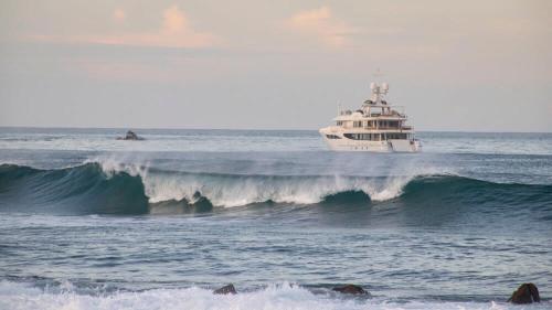 a boat in the ocean with a large wave at Romantic Mediterranean Escape by the Sea in La Majahua