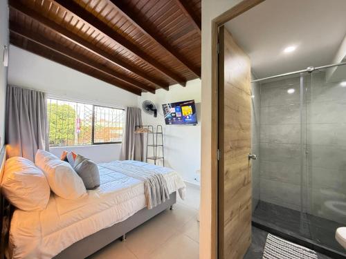 a bedroom with a bed and a glass shower at Laureles Boutique Stay in Medellín
