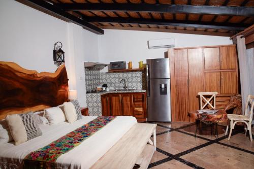 a bedroom with a bed and a kitchen with a refrigerator at Casa Miura Hotel Boutique in Ajijic
