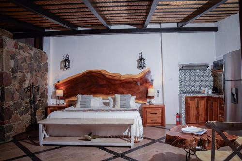 a bedroom with a large bed with a wooden headboard at Casa Miura Hotel Boutique in Ajijic