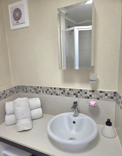 a bathroom with a sink and a mirror and towels at 1 bed Apartment in hatfield in Pretoria