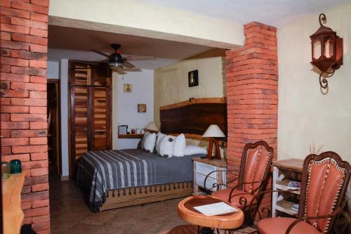 a bedroom with a bed and a brick wall at Casa Miura Hotel Boutique in Ajijic