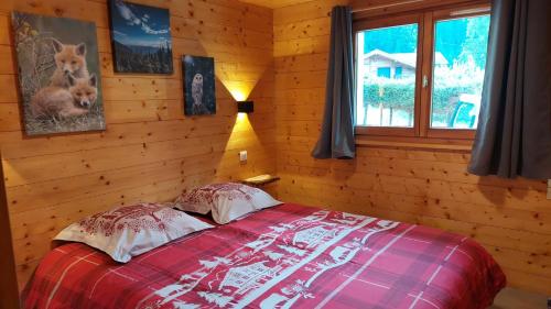une chambre avec un lit dans une cabane en rondins dans l'établissement Nouveau le Ské chalet, terrain clôturé, garage, animaux acceptés, proche lac, à Gérardmer
