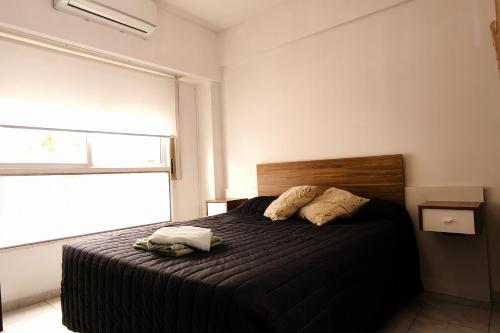 a bedroom with a bed with two pillows and a window at departamento 4 y 59 in La Plata