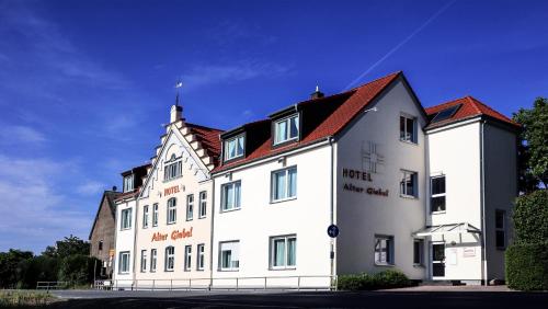 a large white building with a red roof at Hotel Alter Giebel in Bottrop-Kirchhellen