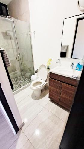 a bathroom with a toilet and a sink and a shower at Marina Cerritos de Lujo - Azul Cielo - 5 Albercas in Mazatlán