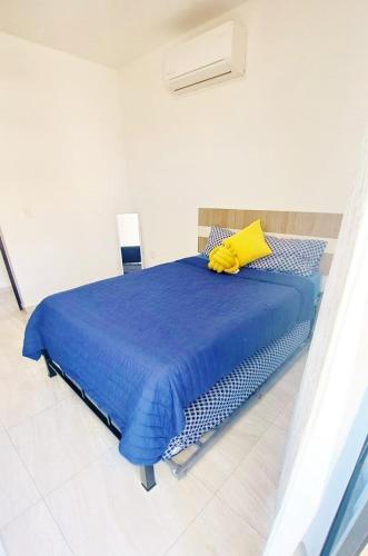 a bedroom with a blue bed with a yellow pillow at Marina Cerritos de Lujo - Azul Cielo - 5 Albercas in Mazatlán