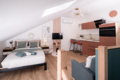 a bedroom with a king sized bed and a kitchen at Ô Perchoir des rêves au centre Millau in Millau