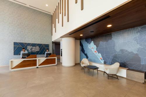 a lobby with a woman sitting at a desk in a building at Holiday Inn Express & Suites Mazatlan by IHG in Mazatlán