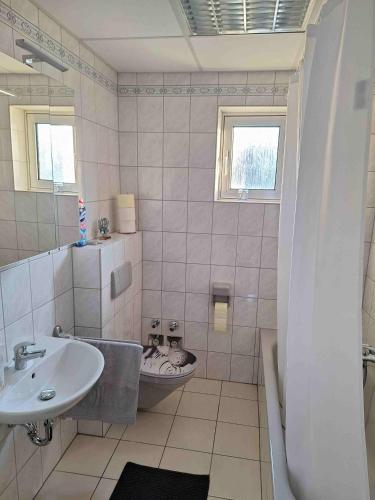 a bathroom with a sink and a toilet and a tub at Ferienwohnung Missionshausstrasse in Sankt Wendel