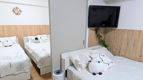 a room with two beds with stuffed animals on them at MIYAVI#101 3min walk from Narimasu Station, up to 6 people, spacious popular character room, Tokyo's largest Don Quijote in Tokyo