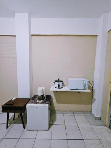 a kitchen with a refrigerator and a microwave on a counter at Apartamento Rua Teresa in Petrópolis