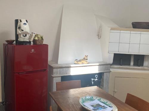 eine Küche mit einem roten Kühlschrank und einem Holztisch in der Unterkunft La Piazzetta in Cantalupo nel Sannio
