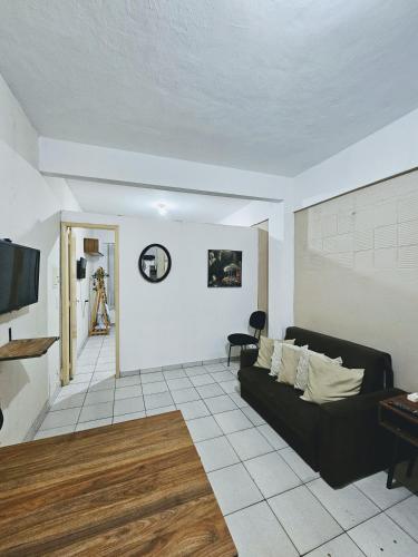 a living room with a black couch and a tv at Apartamento Rua Teresa in Petrópolis