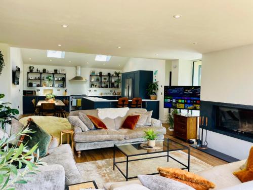 a living room with two couches and a tv at The Cuckoo's Retreat - Luxurious home with private garden & jacuzzi in Kenwyn