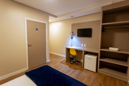 a small room with a desk and a computer at Hiber Hotel - Acesso a Chapecó in Chapecó