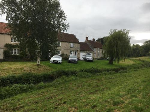 three cars parked in the yard of a house at Willow Cottage in Settrington