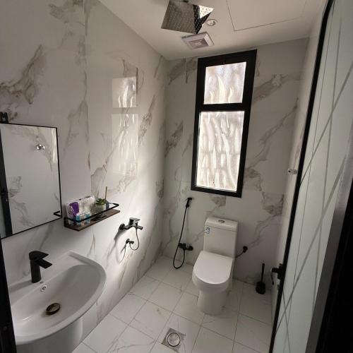 a white bathroom with a sink and a toilet at 1BR, Living Room , 2m to sea in Dammam