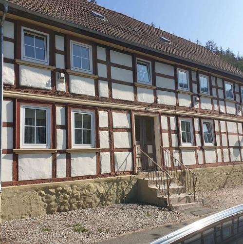a building with a porch and stairs in front of it at Haus Lauterberg 1 - Das Urlaubsdomizil im Harz in Bad Lauterberg